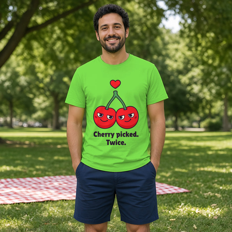 Man with dark curly hair and a short beard wearing the lime green Cherries tee in a park