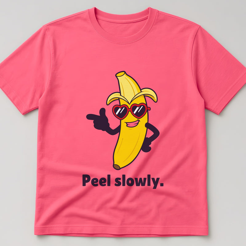 Coral Silk t-shirt, flat lay, printed with a half-peeled banana in sunglasses pointing forward and the words 'Peel slowly.'