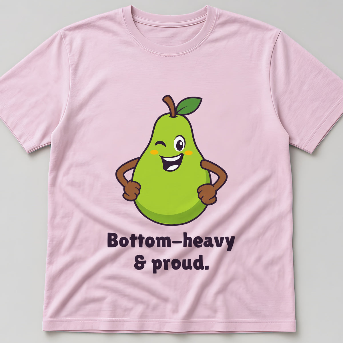 Light pink t-shirt, flat lay, printed with a grinning pear with its hands on its hips and the words 'Bottom-heavy & proud.'