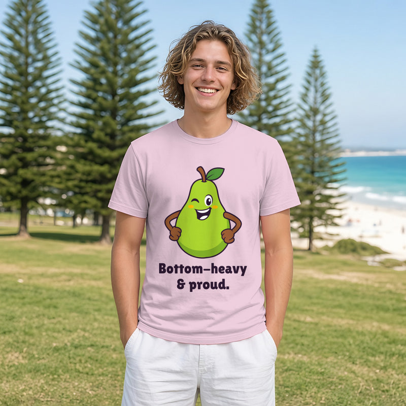 Man with wavy light-brown hair wearing the light pink Proud Pear tee in a park by the beach