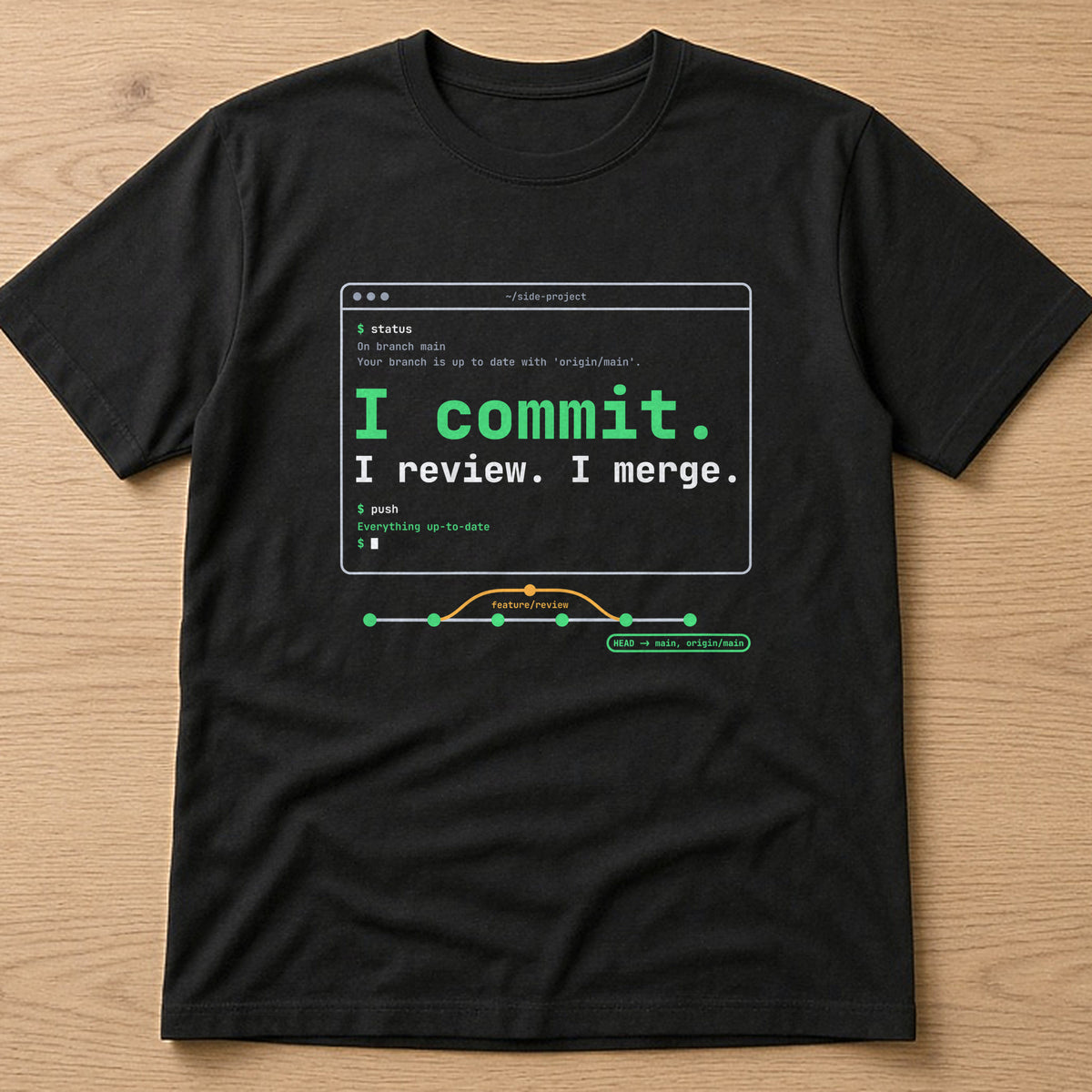 Black t-shirt, flat lay, printed with the clean version: 'I commit. I review. I merge.'