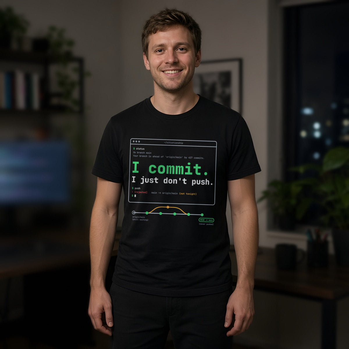 Man wearing a black t-shirt printed with 'I commit. I just don't push.' (Spicy version), at a coding desk. Model image is digitally generated. The print shown is the actual design; colours and fit may vary slightly, see size chart.