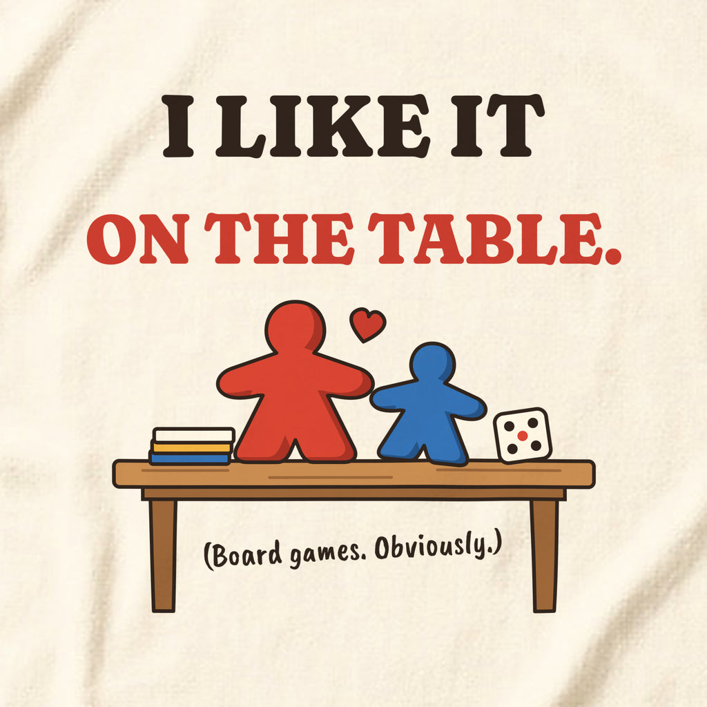 Close-up of the 'I like it on the table. (Board games. Obviously.)' print on a natural t-shirt