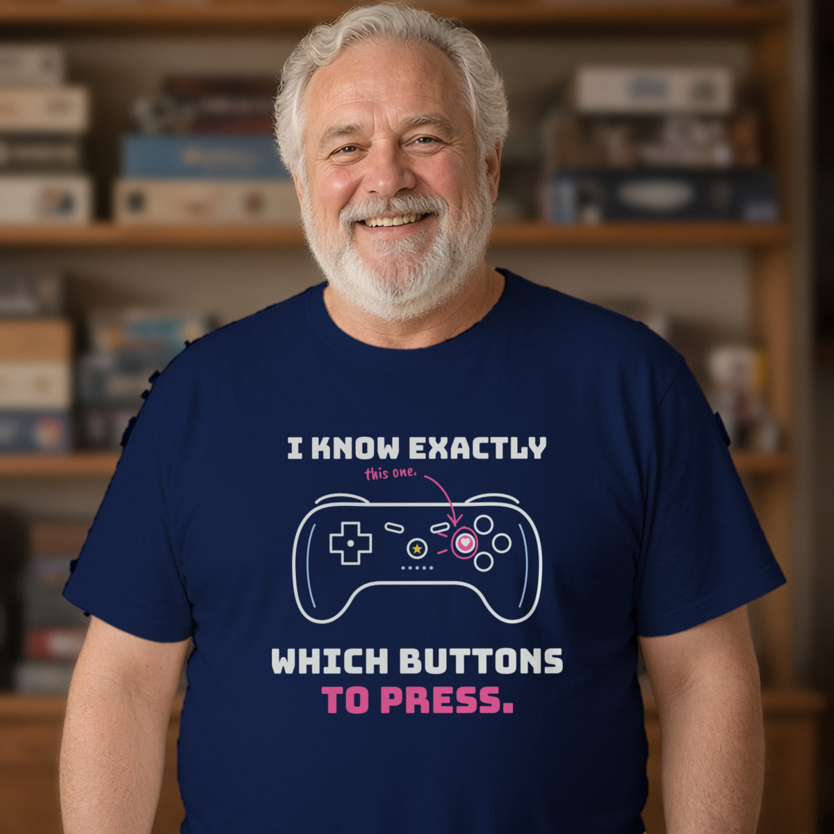 Man wearing a navy t-shirt printed with 'I know exactly which buttons to press.' (Spicy version), in a living room. Model image is digitally generated. The print shown is the actual design; colours and fit may vary slightly, see size chart.