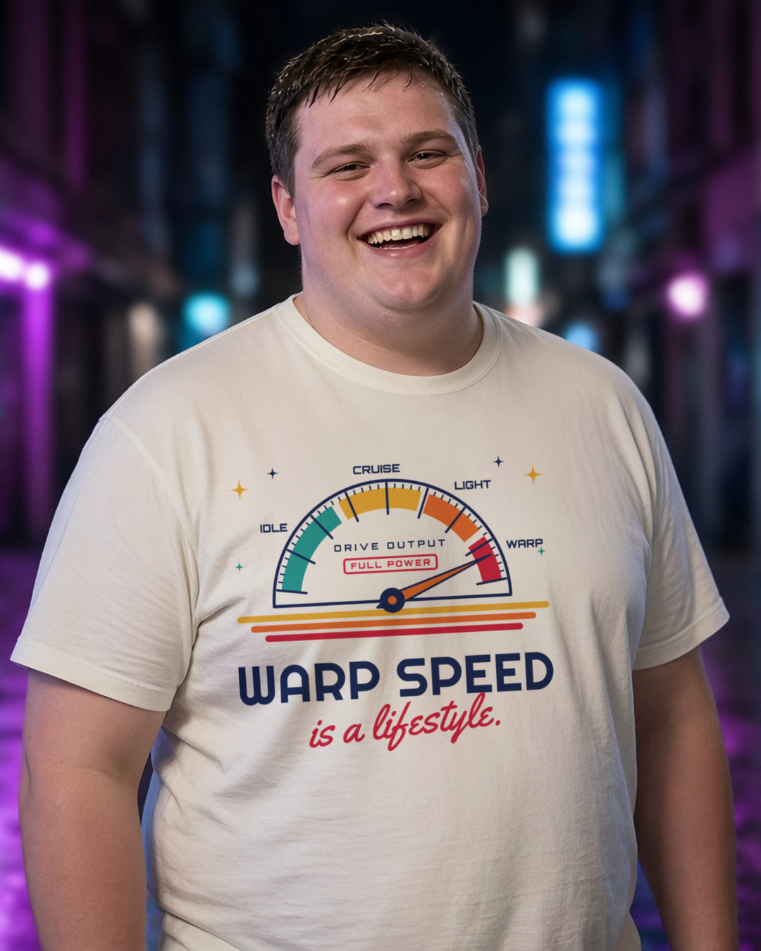 Man wearing a natural t-shirt printed with 'Warp speed is a lifestyle.' (clean version), in a neon-lit laneway (4:5 crop). Colours and fit may vary slightly, see size chart.