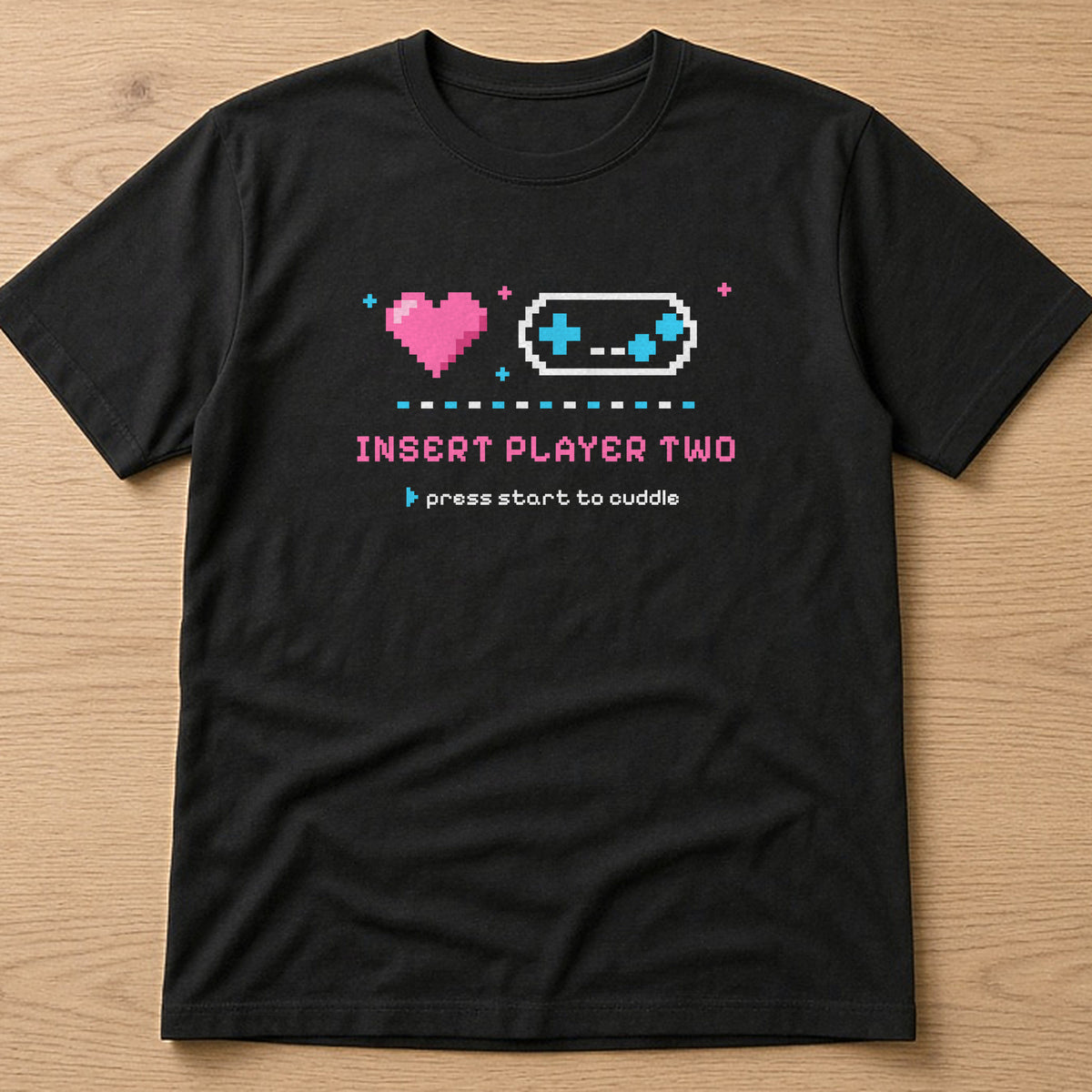 Black t-shirt, flat lay, printed with 'Insert Player Two / press start to cuddle'