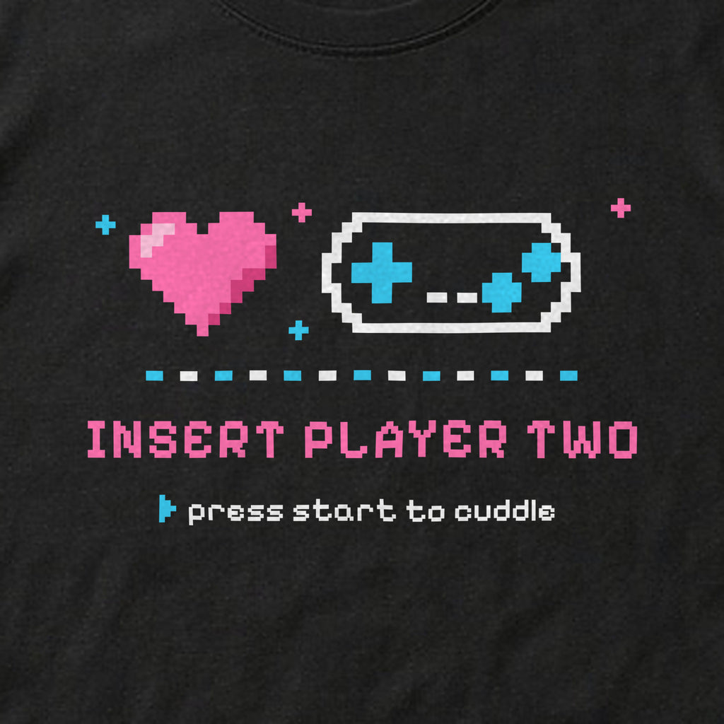 Close-up of the 'Insert Player Two / press start to cuddle' print on a black t-shirt