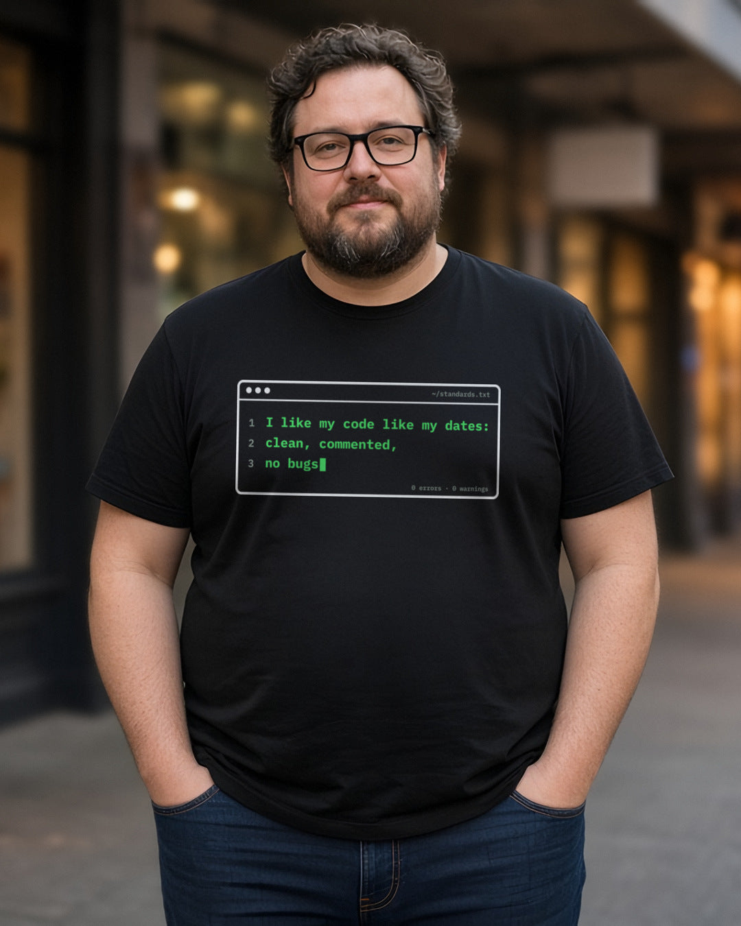 Man wearing a black t-shirt printed with 'I like my code like my dates: clean, commented, no bugs' (Spicy version), on a street at dusk (4:5 crop). Model image is digitally generated. The print shown is the actual design; colours and fit may vary slightly, see size chart.