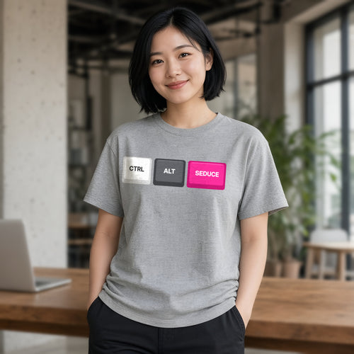 Woman wearing a sport grey t-shirt printed with Ctrl Alt Seduce keycaps (Spicy version), in a cafe. Model image is digitally generated. The print shown is the actual design; colours and fit may vary slightly, see size chart.